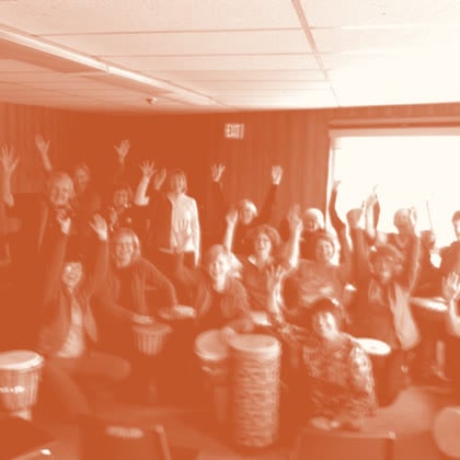 A drum circle group throwing their hands up in celebration