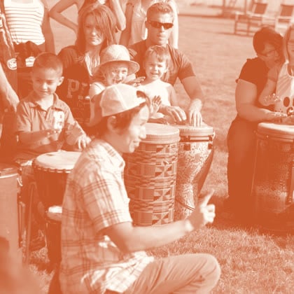 Marcus Fung guiding families and kids in an outdoor drum circle
